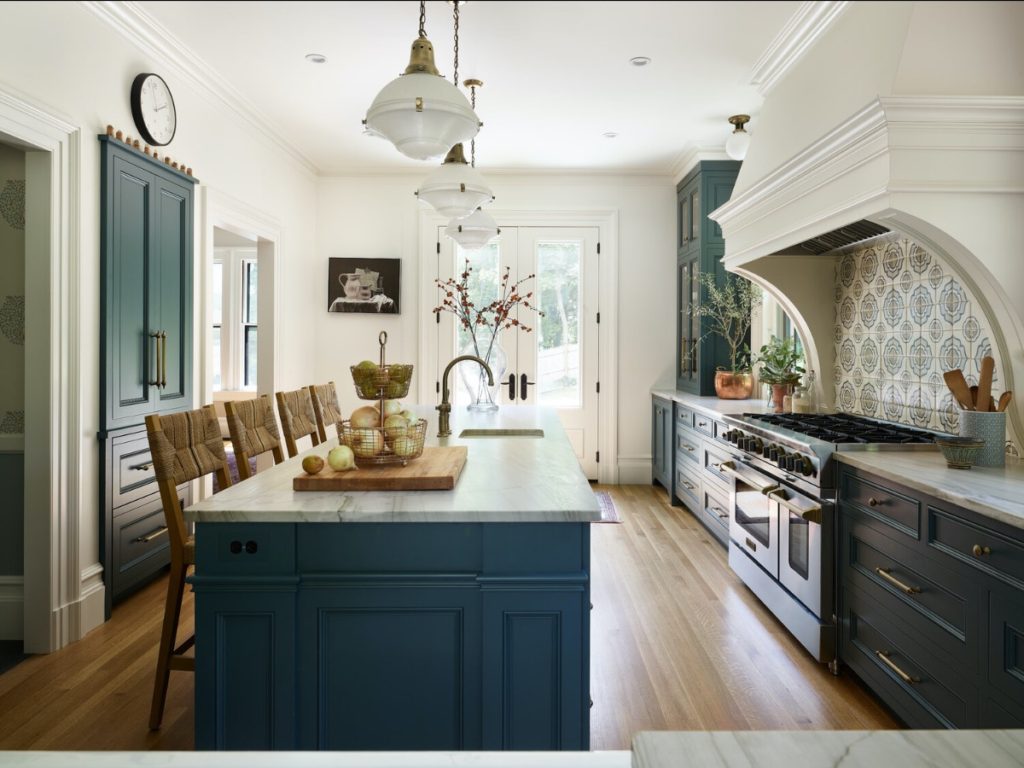 Timeless kitchen design: Blue cabinets, an island with a marble countertop, and lots of light from French doors.
