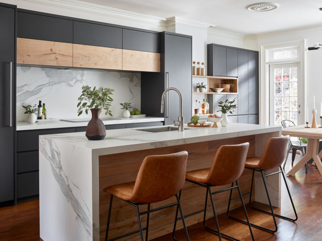Modern kitchen design: sleek charcoal and pine cabinets, a marble breakfast bar, and a marble backsplash.